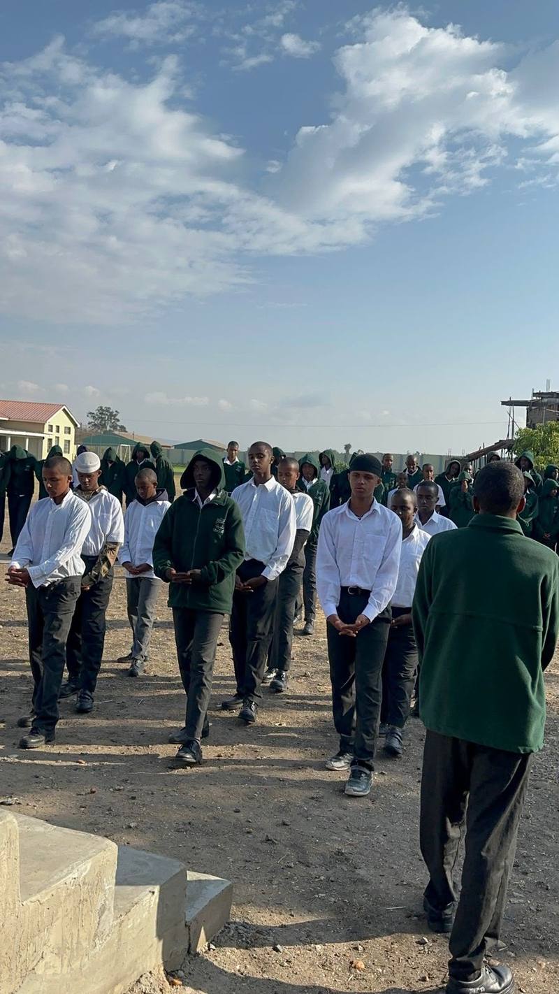 Students gathered in rows on the school grounds