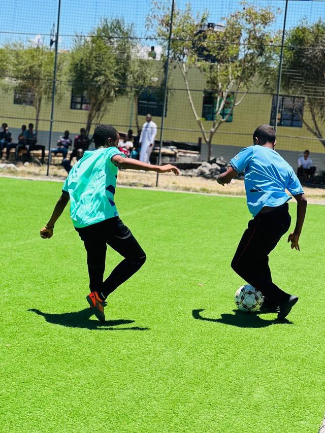 Two students competing for the ball during a match